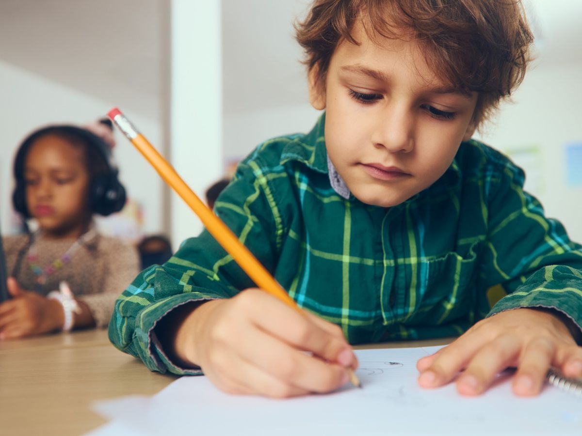 A student writing in a notebook during class